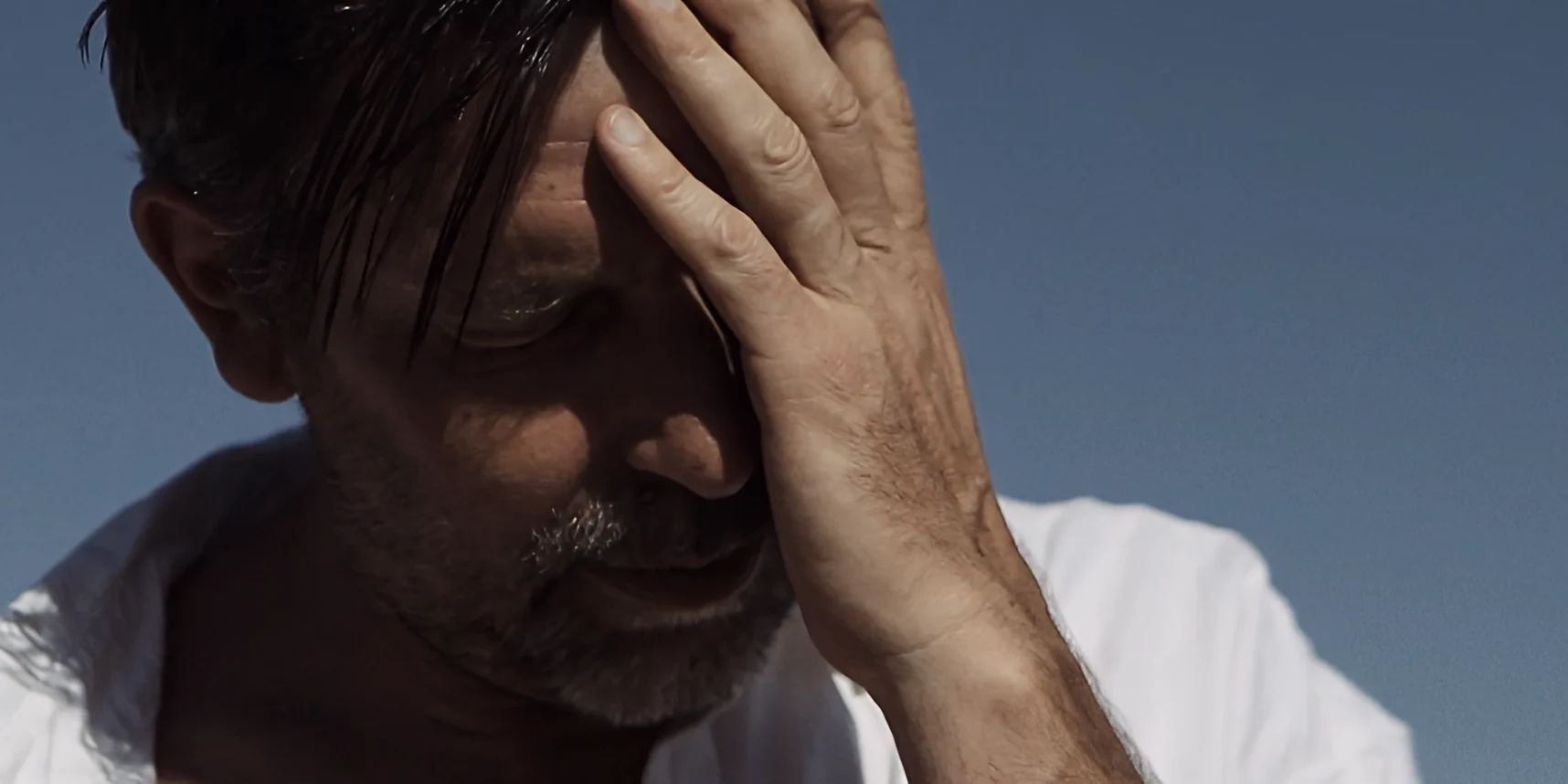 Close-up of man in white wiping sweat from his face in hot Joshua Tree desert, 88 short film
