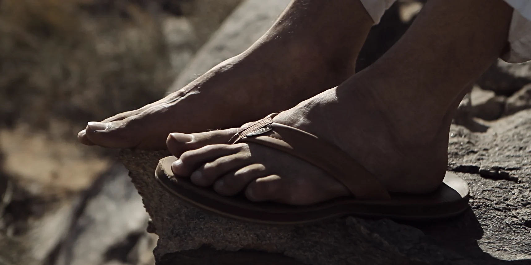 Close-up of feet on rock, one in sandal other bare, Joshua Tree desert, 88 short film