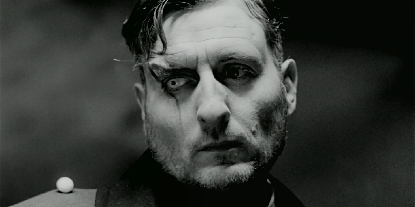 Black-and-white close-up of man with scarred face and eerie white eye staring intensely to the side, Clone short film