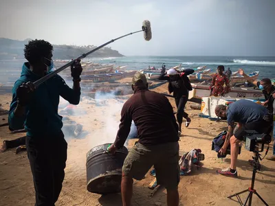 Film shoot for 'ZERO' on the beach of the Mosque of the Divinity in Dakar: crew filming extras running through explosion smoke