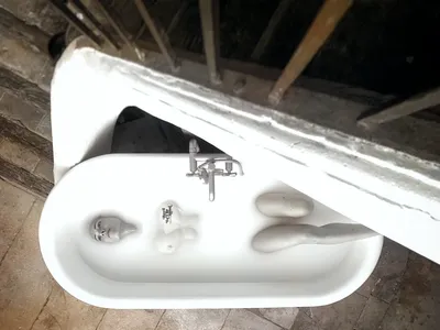 Monochrome top-down shot of a model submerged in a bathtub filled with milk, fashion photography