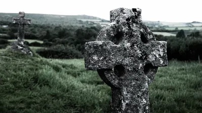 Celtic cross covered in moss and lichen, southern England countryside